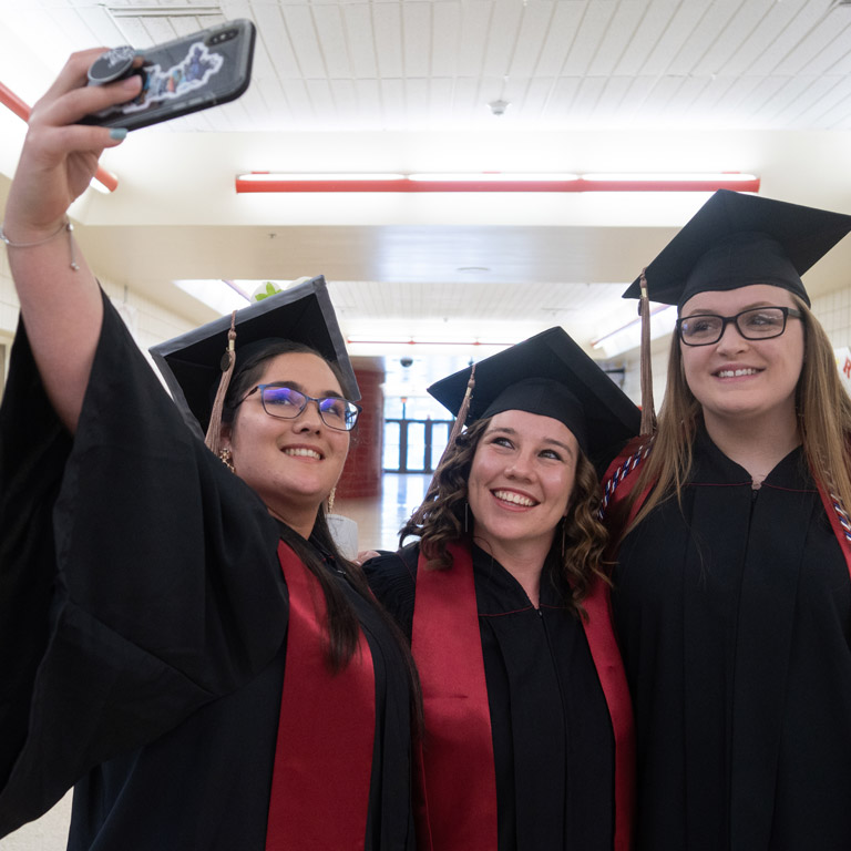 Three female graduates pose for a selfie