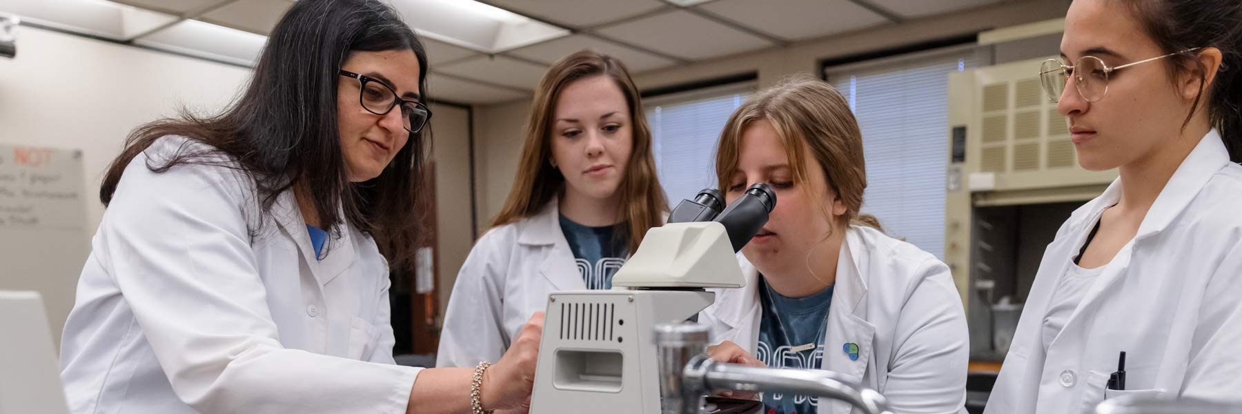 Faculty member Parul Khurana teaching students in a science lab.