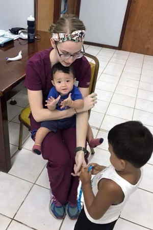 Amber Huelskamp caring for children in Belize clinic.