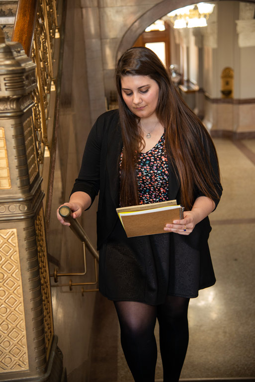 Caysey reviewing materials while climbing stairs in the Rush County courthouse.