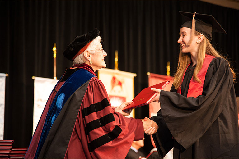 Chancellor Girten handing diploma to newly graduated student at Commencement.