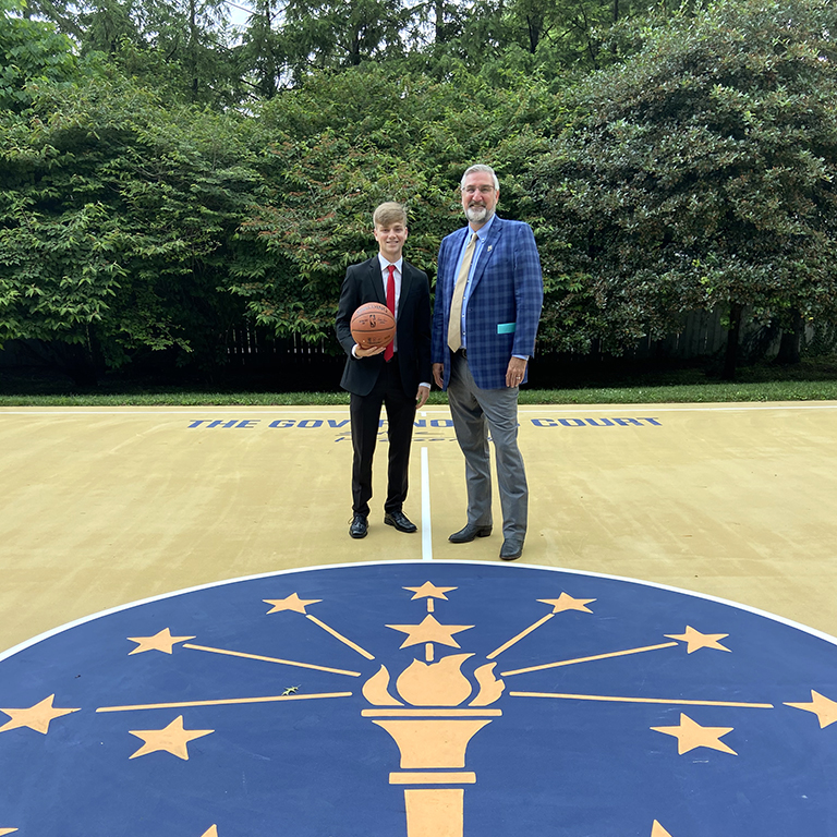 Photo of Cole Fosbrink with Gov Holcomb on the state symbol
